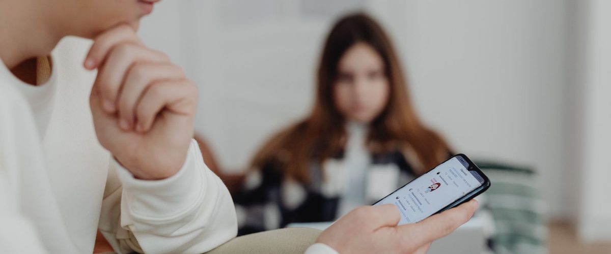 En ung holder en telefon i hænderne